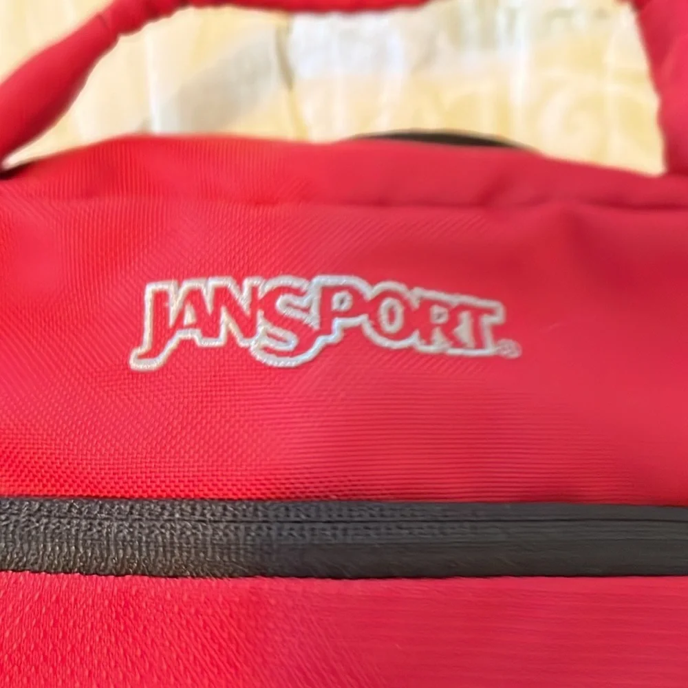 Red Jansport laptop messenger bag. Interior Velcro & outer zippered compartment
